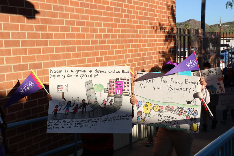 Students hold up signs they drew, commemorating Ruby Bridges