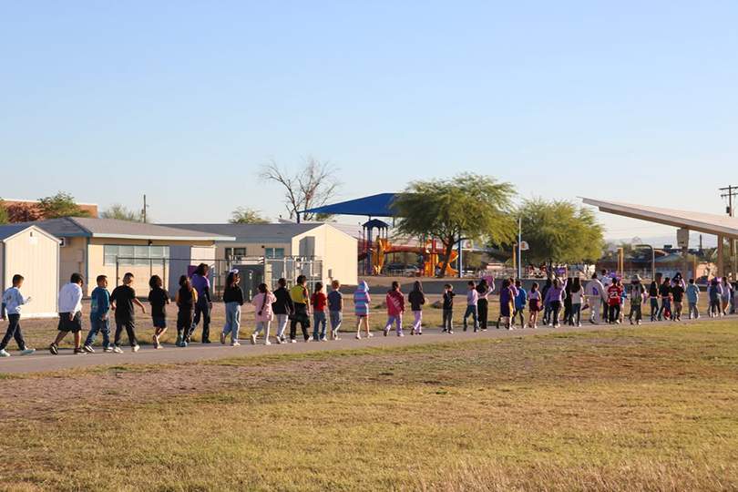 A line of students walking around the campus